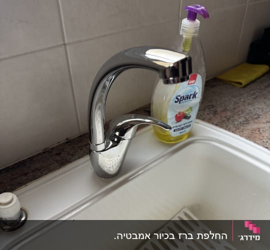 ברז כיור עם בקבוק סבון נוזלי לידו